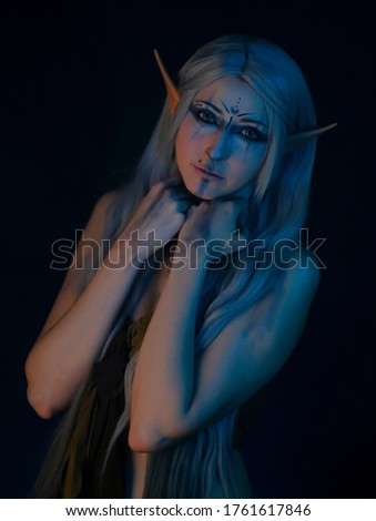 beautiful girl with long hair posing in elf cosplay with colored lights. High quality photo