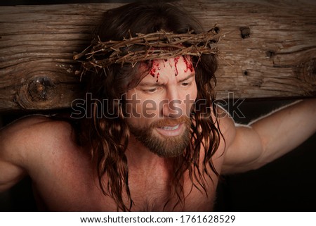 Jesus Christ wearing crown of thorns and hanging on the crucifixion cross