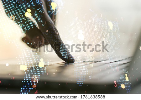 Double exposure of social network icons concept with world map and hand typing on computer keyboard on background. Networking concept