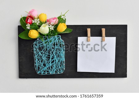 Mockup layout with flowers on grunge black wooden background. Copy space. 