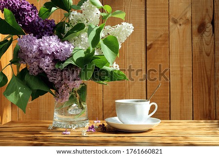 still life, a bouquet of lilacs with a cup of tea in the early morning