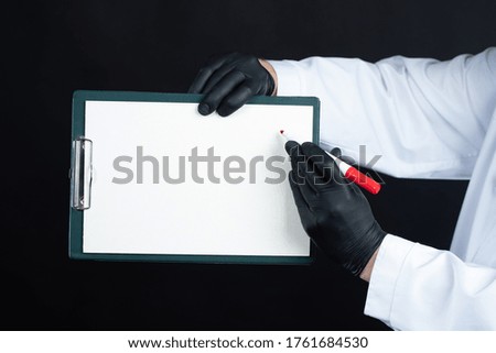 Medical information. A man in a white coat is holding a tablet and a marker. A placard with a place for the text in the hands of a doctor. New treatment.