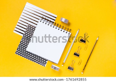 Back to school concept notepad, pencil case, stationery and school supplies. Top horizontal view copyspace yellow abstract background