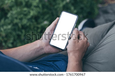 cell phone mockup image blank white screen.man hand holding texting using mobile on desk at coffee shop.background empty space for advertise.work people contact marketing business,technology