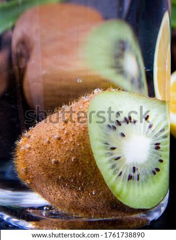 Close shot of a kiwi slice which has been put in a glass of water