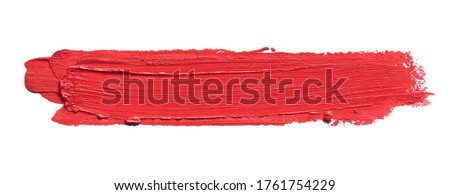 Red lipstick smear smudge isolated on white. Red color brush stroke close up. Makeup cream texture background