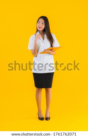 Portrait beautiful young asian doctor woman with empty white board on yellow isolated background