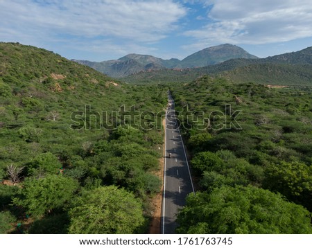 drone shot aerial view mountain road valley forest trees bright sunny day beautiful scenery background wallpaper 