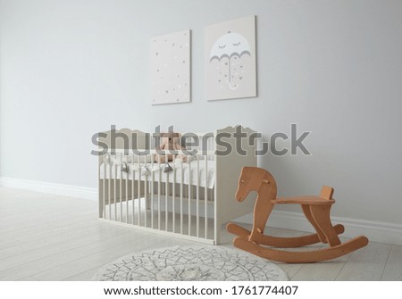 Minimalist room interior with baby crib, decor elements and toys