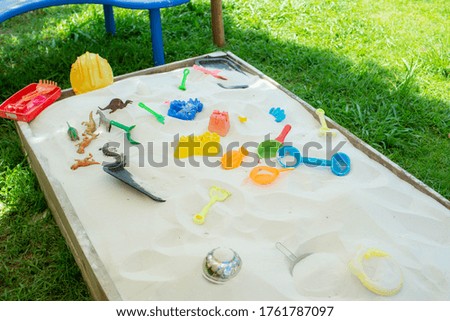 Bright plastic children toys in sandpit in kindergarten 
