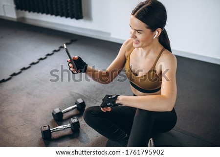 Young woman aercising at the gym with dumbbells