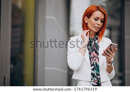 Classy business woman in white suit talking on the phone