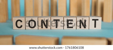 Word CONTENT made with wood building blocks on a blue table with wooden background.