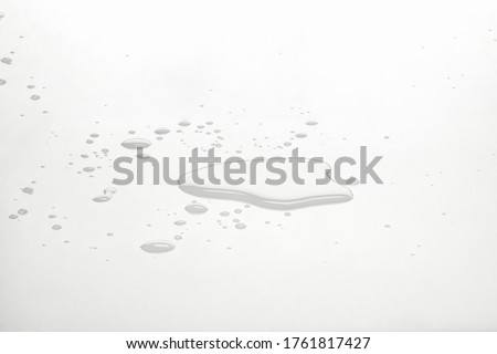 Water puddles and droplets on white reflective surface. Frontal view and deep focus. Royalty-Free Stock Photo #1761817427