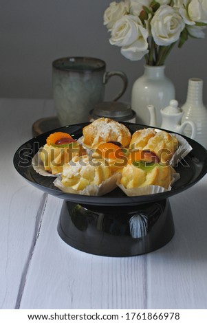 Choux pastry cake in a plate, on white table