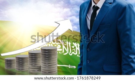 Business concept of increasing sales, Businessman on the background of the flag of Saudi Arabia and a graph of increasing up.