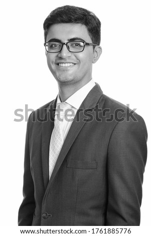 Portrait of happy young handsome Persian businessman wearing eyeglasses
