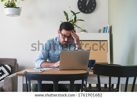 Young businessman having some problems while working at home stock photo