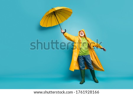 Full length body size view of his he cheerful cheery dreamy grey-haired man wearing yellow topcoat bad cold weather cyclone day isolated over bright vivid shine vibrant blue color background