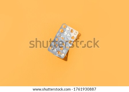 Started plate of pills with jelly shadows on a yellow background. Flat lay, place for text