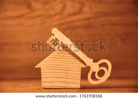 home key lie on roof of wooden house . wood  background.  home sweet home concept, empty copy space