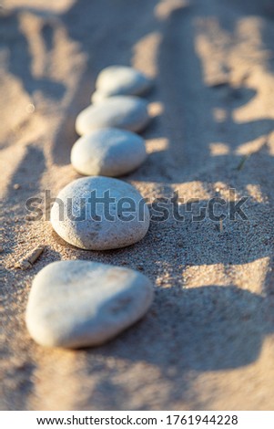 Lined smooth pebbles in the sand, Copy space