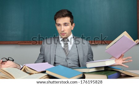 Young teacher sitting in school classroom