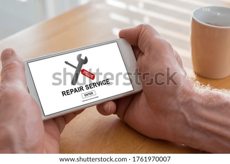 Male hands holding a smartphone with repair service concept