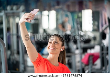 Young fit woman taking selfie in gym
