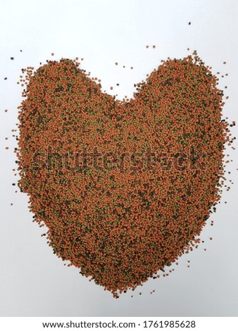 A pile of heart shaped fish food on a white background
