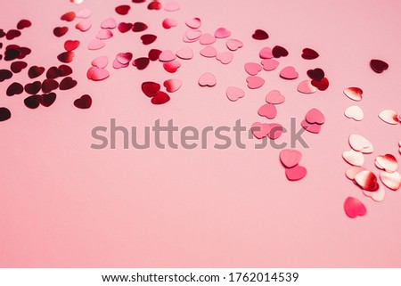 Romantic red and pink festive backround with red heart shaped confetti. Love, dating and Valentines Day concept. Soft focus, copy space