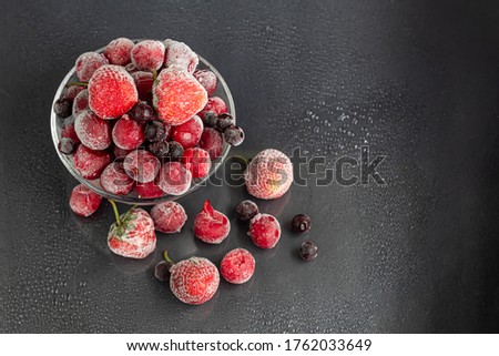 Frozen fruits. Frozen fruit mixture of currants, cherries and strawberries. Vitamin Blend. On a dark background.