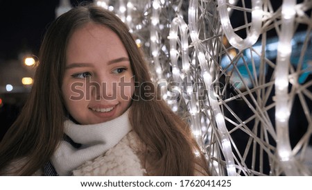 Happy girl on the background of Christmas garland.