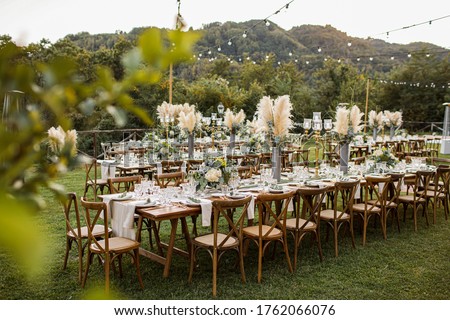 Wedding table set up in boho style with pampas grass and greenery, soft focus