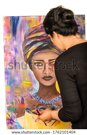 Brunette woman painting portrait of african woman on canvas against white background