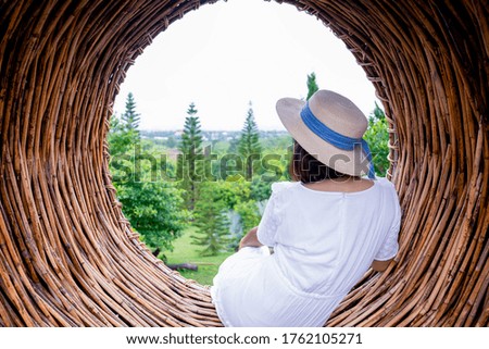 Woman sitting in circles sofa with pine trees view