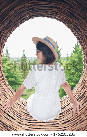 Woman sitting in circles sofa with pine trees view