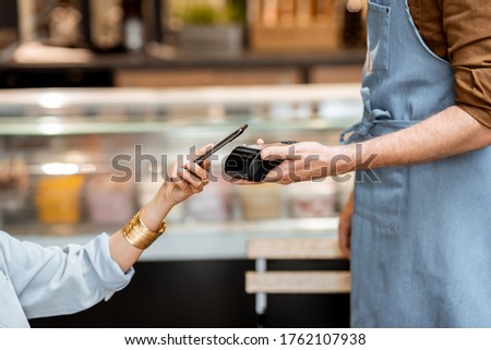 Female client paying by phone contactlessly at the cafe, close-up Royalty-Free Stock Photo #1762107938
