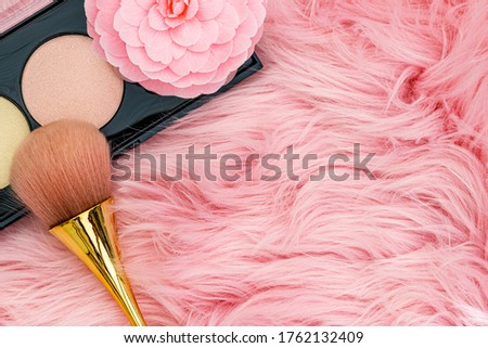 Pink Camellia flower and make up brush on fur trendy background. Professional Make up Brush on pink fur  fabric, close up 