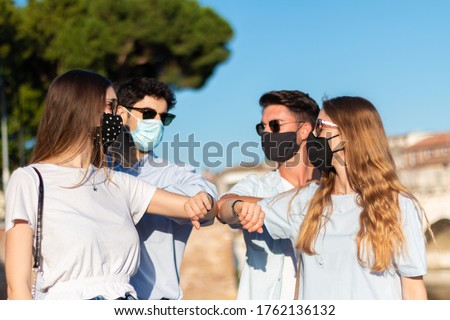 friends  cheers with elbows - four young persons say hello in the time of coronavirus Royalty-Free Stock Photo #1762136132