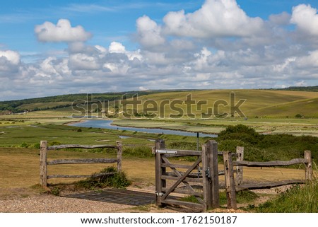 Looking out over the Cuckmere River in Sussex with a cattle grid and gate in the foreground