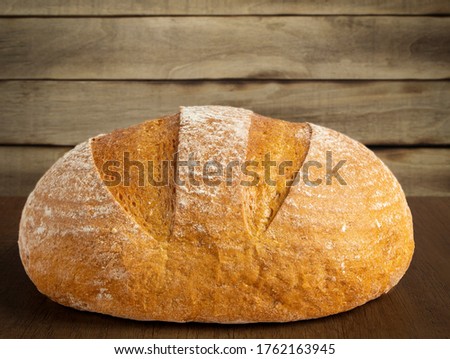 Freshly baked bread on a wooden background. Homemade Crusty Brown Bread
