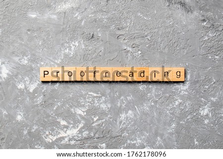proofreading word written on wood block. proofreading text on table, concept.