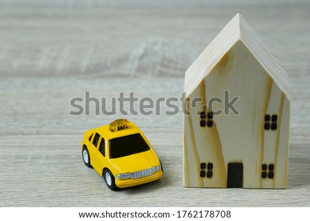 Toy cars and wooden houses in concept of buying housing and insurance or Travel concept.