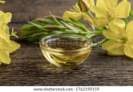 Evening primrose oil and plant on a table Royalty-Free Stock Photo #1762190159