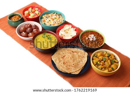Indian whole meal with yellow dal, vegetable pulao, chapati,gulab jamun, salad, papad, pickle, chana masala curry and aloo gobi Royalty-Free Stock Photo #1762219169