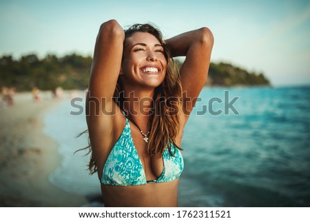 Portrait of an attractive young woman is posing and having fun at the tropical beach.