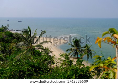 Paradise beach point of view. Maharashtra. India. Azure sea. Palms, boats and people. Horizon. Blue lagoon. Beautiful coastline at sunny day. Turquoise water. Selective focus  Royalty-Free Stock Photo #1762386509