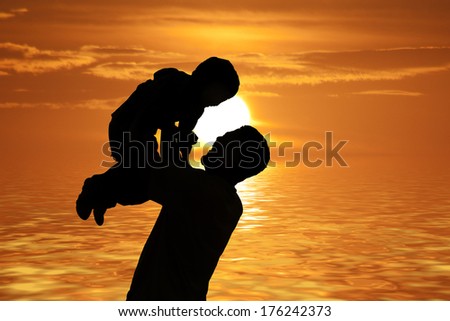 Silhouette of a man and his son with sunset at the beach background