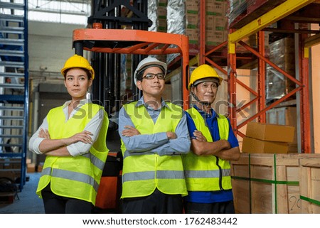 Portrait of warehouse worker standing at large warehouse,Staff meeting concept.